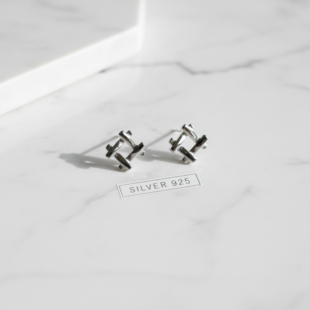 Silver 925 geometric earrings on white marble surface