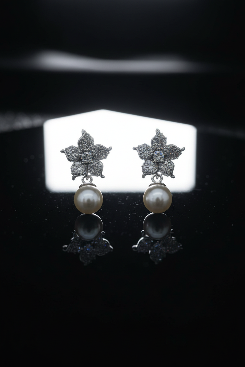 Pearl earrings with dramatic backlighting on black surface